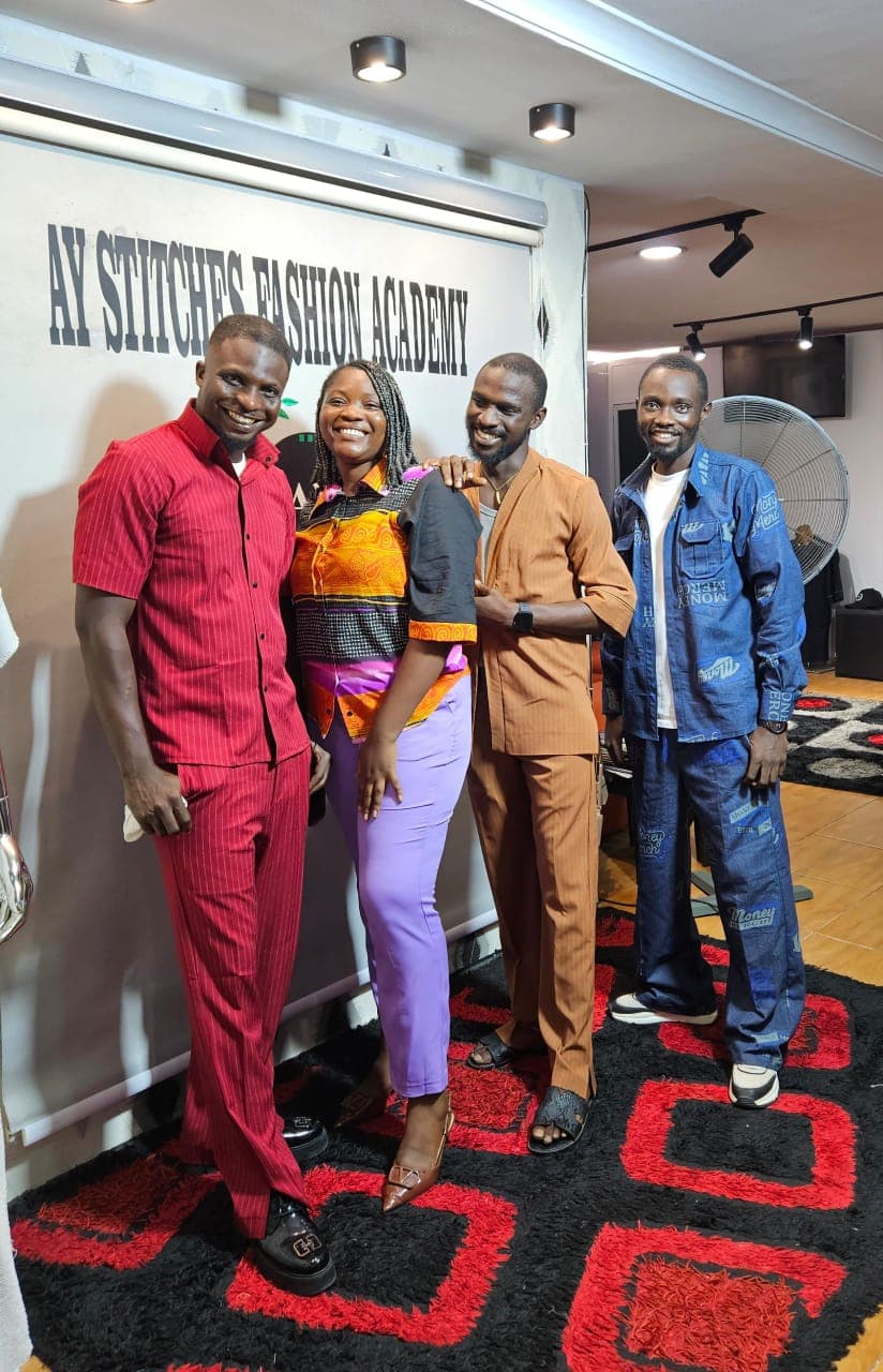 Four graduates posing together in colourful outfits