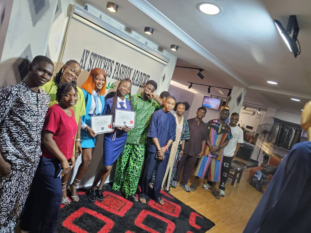 Graduates posing together at the Ay Stitches presentation event
